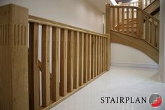 an empty room with white floors and wooden handrails on the second story stairs