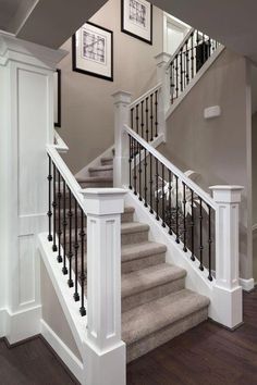 the stairs in this house are white with black railings and balconies on each side