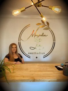 a woman sitting at a counter in front of a sign