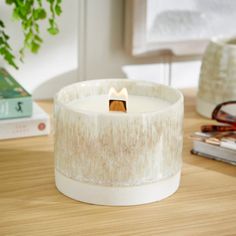 a white candle sitting on top of a wooden table