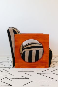 a chair made out of wood with a black and white striped pillow on top of it