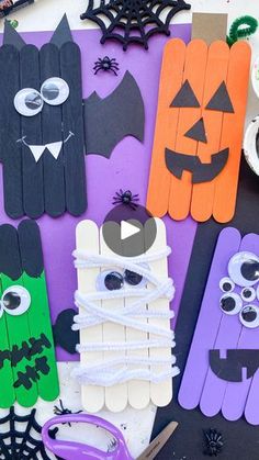 halloween crafts made from popsicle sticks and construction paper are displayed on a table with scissors