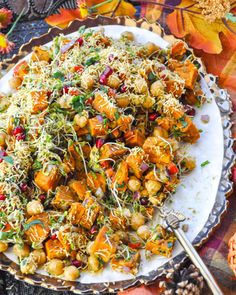 a white plate topped with vegetables and sprouts on top of a plaid table cloth