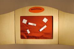 an orange bulletin board with some white stickers on it