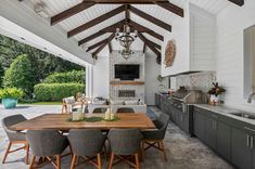 an outdoor kitchen and dining area with wood beams