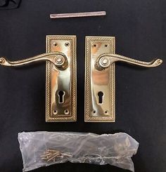 two antique brass door handles and latches