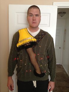 the man is wearing an ugly christmas sweater and holding a banana in front of his face