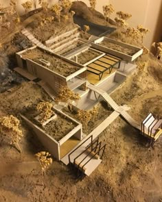 an architectural model of a house in the middle of dirt with stairs leading up to it