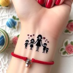 a woman's hand with a tattoo on it and a red string around her wrist