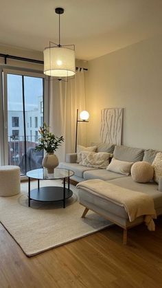 a living room filled with furniture next to a large glass sliding door leading to a balcony