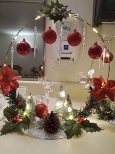 some christmas decorations on a table with lights and baubles hanging from the top