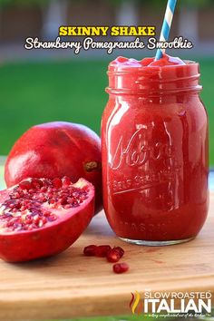 a close up of a pomegranate in a mason jar with a straw