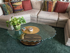 a living room filled with furniture and pillows on top of green carpeted flooring