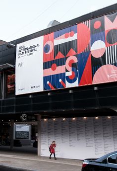 an advertisement on the side of a building for international film festival, with people walking by