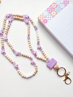 a purple and white beaded necklace next to a pair of scissors