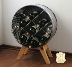 a wine rack with many bottles in it sitting on a wooden stand next to a wall