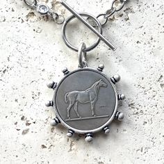 Expertly crafted and designed for longevity, the Cora Silver Horse Coin Necklace is the perfect accessory for any equine enthusiast. The handcrafted, non-tarnishing stainless steel chain ensures durability for years to come. Complete your look with this unique and elegant piece. Cora Silver Horse Coin Necklace Coin Pendant Approximate Size 30mm MADE IN USA Pearl Cluster Necklace, French Coins, Silver Horse, Toggle Necklace, Bee Pendant, Chunky Bracelets, Pearl Cluster, Cluster Necklace, Over Sized