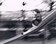 a young boy is sliding down a slide