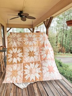 a large quilt on the back porch of a house