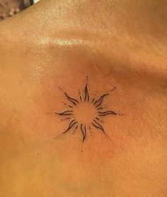 a sun tattoo on the back of a man's chest