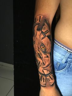 a man's arm with a clock and an animal tattoo on the left side of his body