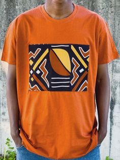 Afrikatja's collection of men's T-shirts blend simplicity with unique style.  Each solid-colored T-shirt features a distinctive applique made from authentic African fabric, sourced directly from Ghana. This carefully crafted detail adds a funky, stylish, and unique touch to the classic T-shirt, making it a standout piece in any wardrobe. Customization is also available--just drop me a message to create your perfect T-shirt! Material: 100% cotton (both T-shirt and applique). Size guidance: see th Black Tshirt Orange Print, Orange T Shirt, Shirt Making, Orange T Shirts, Ethnic Style, African Fabric, Ethnic Fashion, African Print, Tshirt Colors