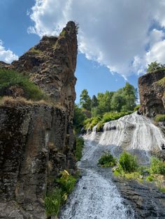 there is a waterfall in the middle of some rocks