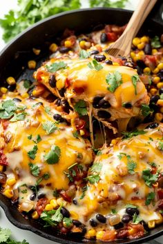 a skillet filled with black beans, corn and cheese covered in cilantro