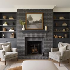 a living room filled with furniture and a fire place in front of a brick fireplace