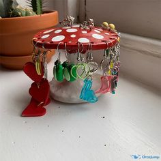 a red mushroom with white polka dots and lots of earrings hanging from it