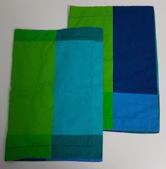 two pieces of blue and green cloth on a table