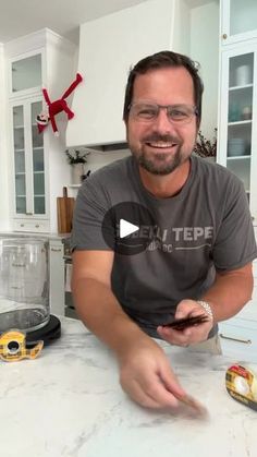 a man sitting at a kitchen counter in front of an air fryer