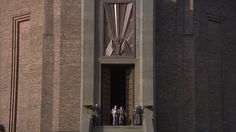 people are standing in the doorway of a building with an organ on it's side