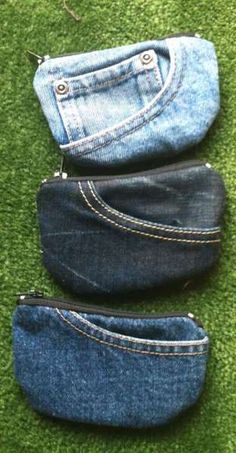 three pairs of jeans sitting on top of a grass covered floor next to each other