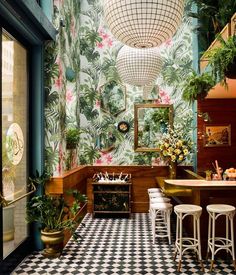 the interior of a tropical themed restaurant with checkered flooring and bar stools