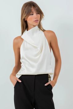 Introducing the Bridget Open Back Cowl Neck Satin Top. Made from high quality fabric, this top boasts a stunning cowl neck and bows on the back for added elegance. Perfect for any occasion, elevate your style with the Bridget top. Model is wearing a size Small Bows on the back detail Cowl neck High quality satin Chic High Neck Blouse For Party, Chic Sleeveless Blouse For Party, Chic High Neck Blouse For Formal Occasions, Chic Fitted Satin Top, Elegant High Neck Satin Top, Elegant High Neck Top For Party, Chic Halter Neck Blouse For Formal Events, Chic Sleeveless Blouse For Evening, Chic Fitted Blouse For Evening