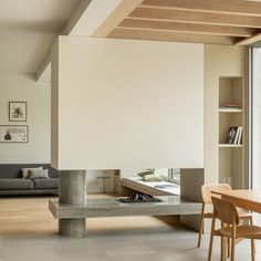 a living room filled with furniture and a fire place next to a wall mounted book shelf