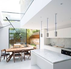 an open kitchen and dining area with white walls