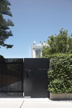 a black gate with the word obama on it in front of some trees and bushes