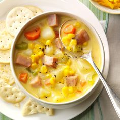 a white bowl filled with soup next to crackers