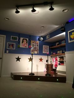 an empty room with blue walls and pictures on the wall, including stars in the ceiling