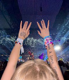 two people with their hands in the air at a concert