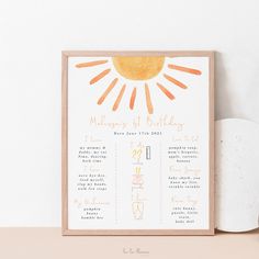 an orange and yellow baby's first year calendar on a shelf next to a cup