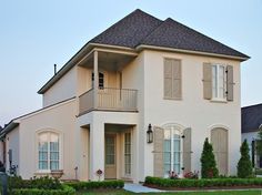 a white house with two balconies on the second floor and three story windows