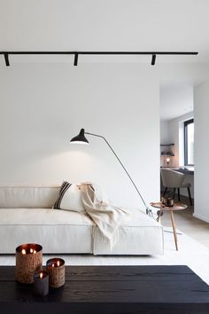 a living room with a white couch and two candles