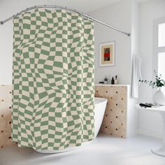 a green and white shower curtain hanging in a bathroom next to a bathtub with a sink