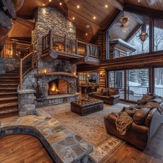 a large living room with wood floors and stone fireplace