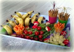 an assortment of fruits and veggies are arranged on a tray with toothpicks