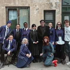 a group of people standing next to each other in front of a building