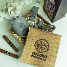 a wooden box filled with two flasks and some other items next to it